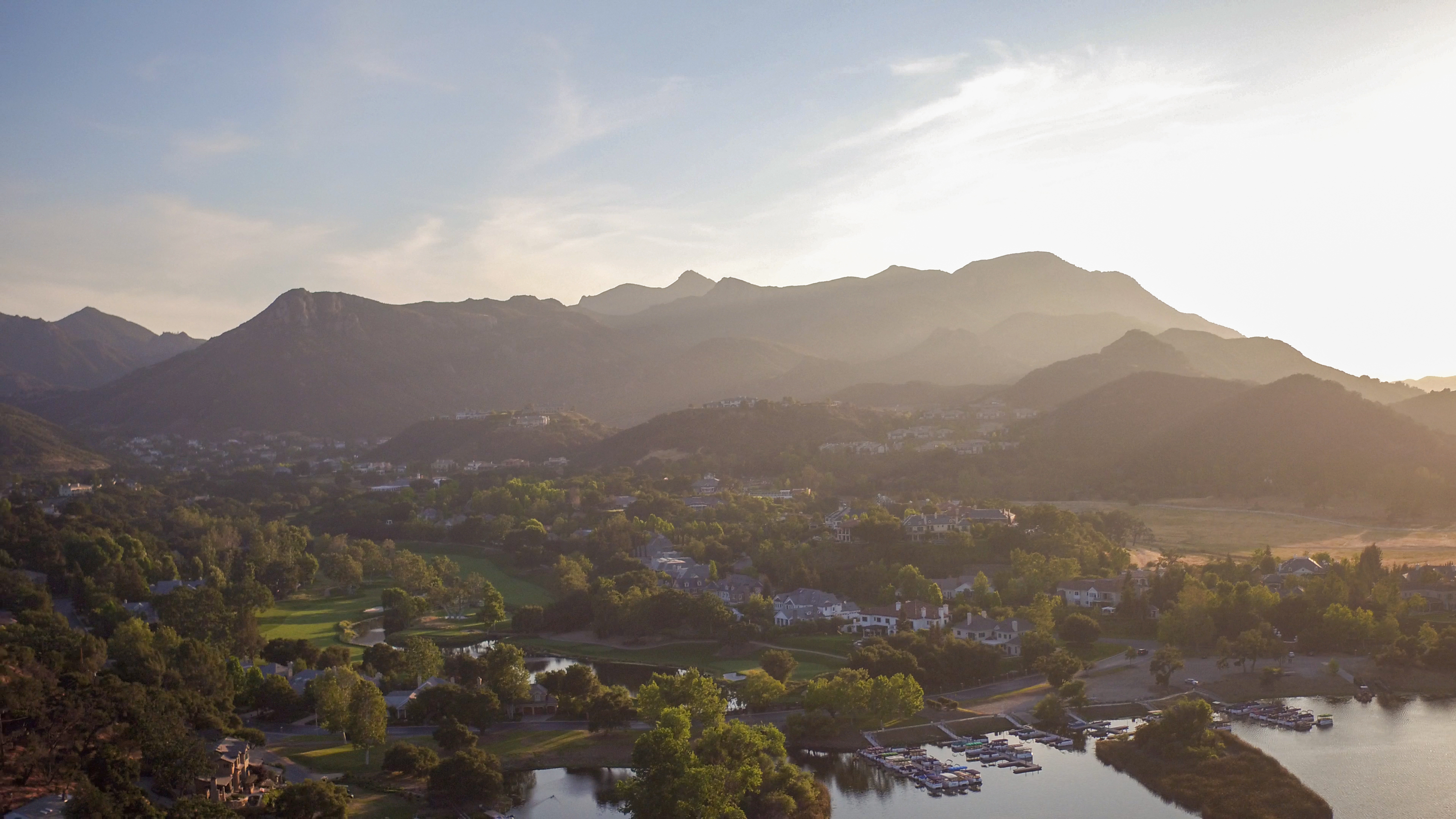Aerial view of Lake Sherwood, California, with the lake, marina and Santa Monica Mountains at sunset